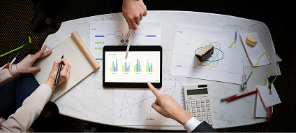 A team reviewing industry trend charts on a tablet around a table